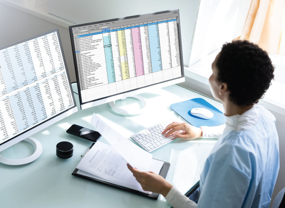 Image of Woman working on dual monitors processing medical claims